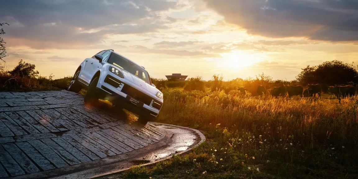 Porsche Cayenne bei Sonnenuntergang im Offroadgelände
